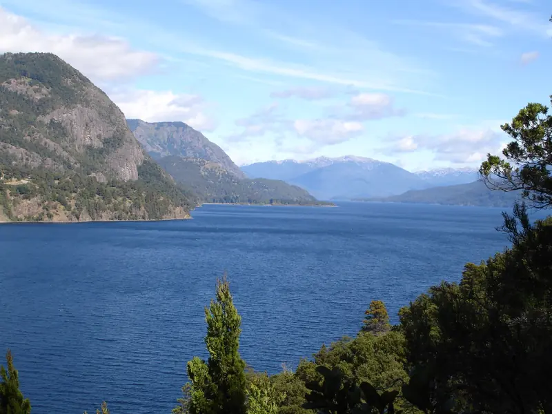 Lago Lácar azul-escuro entre montanhas de encosta rochosa, visto do mirante Bandurrias