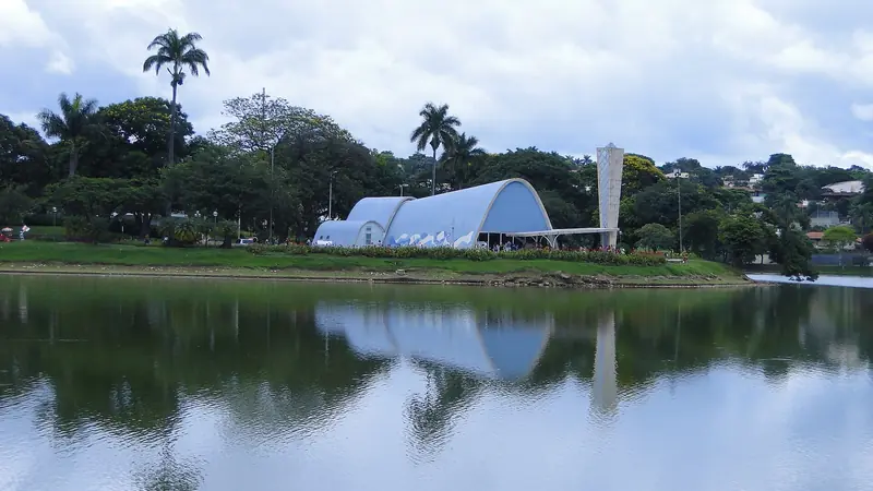 Igrejinha da Pampulha com abóbadas azuis e torre separada, refletida na lagoa