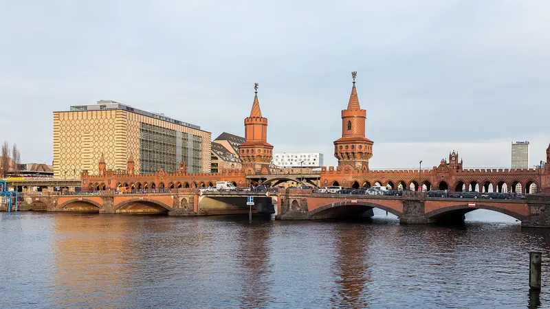 Ponte Oberbaumbrücke, de tijolo vermelho com duas torres e arcos, sobre o rio Spree entre Kreuzberg e Friedrichshain