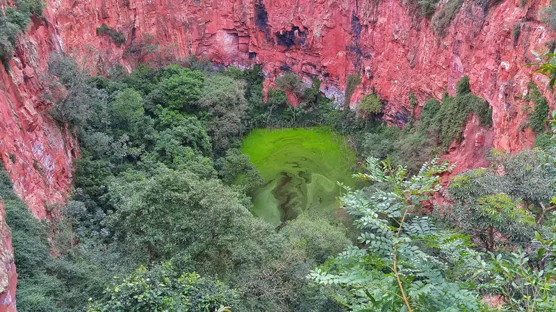 Dolina do Buraco das Araras vista da borda, com paredões vermelhos e lago verde no fundo