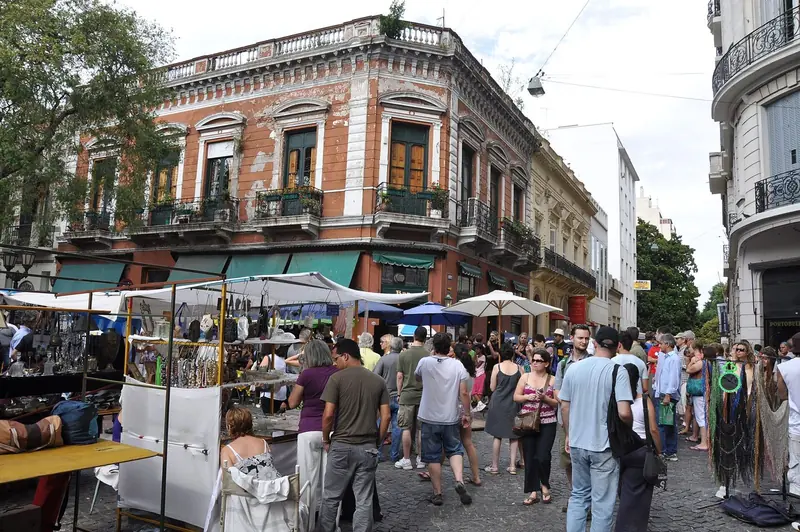 Plaza Dorrego num domingo de feira, com bancas sob toldos e um casarão com sacadas de ferro