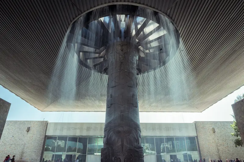 Pátio do Museu Nacional de Antropologia, com a coluna esculpida que sustenta a cobertura de concreto e a cortina de água caindo em volta dela