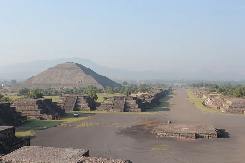 Pirâmide do Sol à esquerda e a Calzada de los Muertos em linha reta até o horizonte, com plataformas de pedra escalonadas dos dois lados