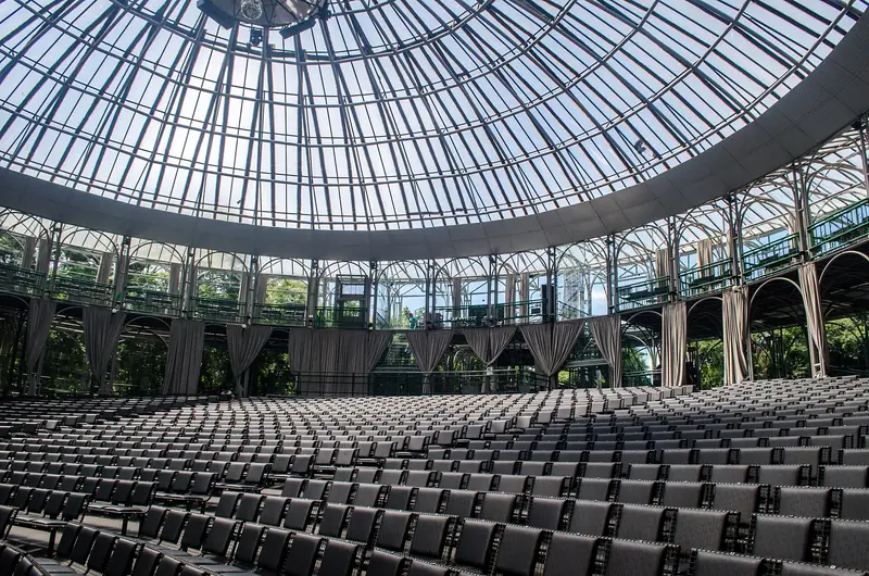 Interior da Ópera de Arame, com fileiras de cadeiras sob a cúpula transparente de estrutura de aço