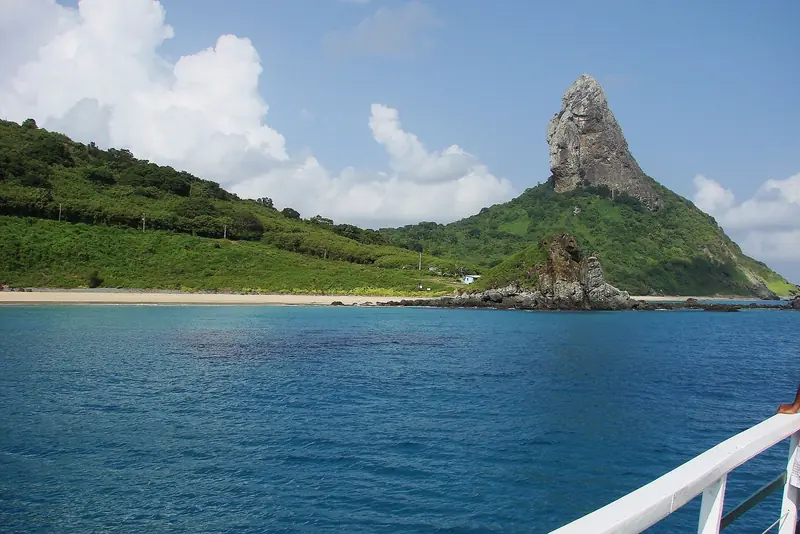 Morro do Pico, pico rochoso coberto de vegetação, visto do mar com a Praia da Conceição ao pé