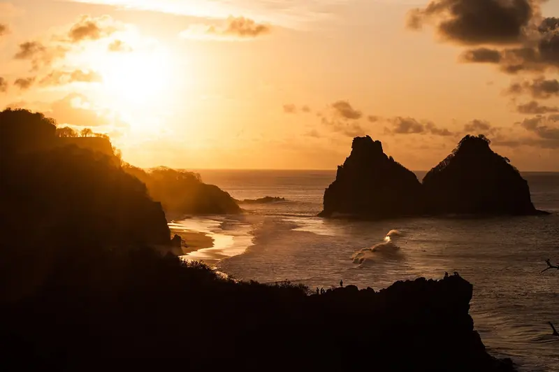 Pôr do sol com a silhueta dos morros Dois Irmãos no mar, visto do Mirante do Boldró