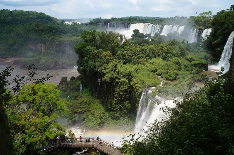 Quedas do lado argentino vistas entre a mata, com uma passarela no canto inferior