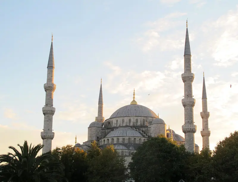 Cúpulas e quatro dos seis minaretes da Mesquita Azul no fim da tarde, acima das árvores do parque