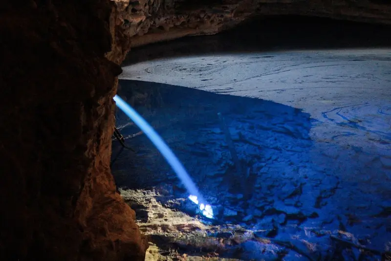 Raio de sol entrando na gruta do Poço Encantado e iluminando a água azul