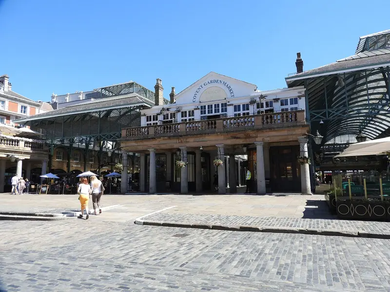 Prédio do mercado de Covent Garden com colunata e piso de paralelepípedo na praça em frente