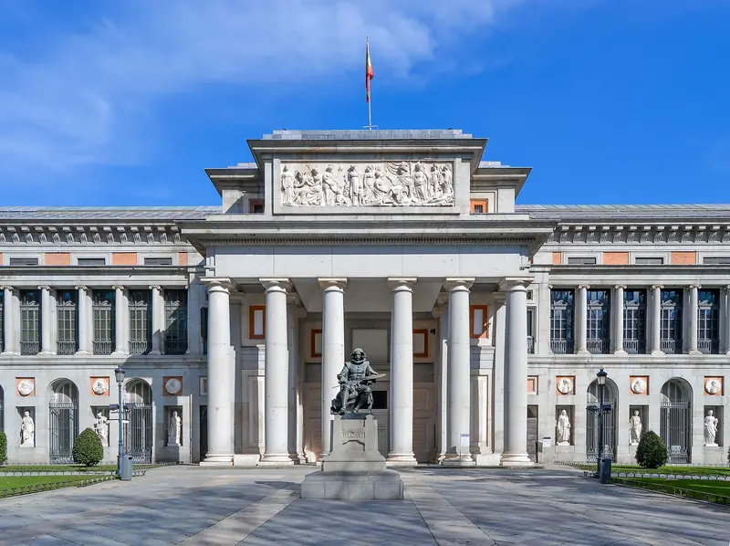 Fachada neoclássica do Museu do Prado, com seis colunas e a estátua de Velázquez diante da entrada