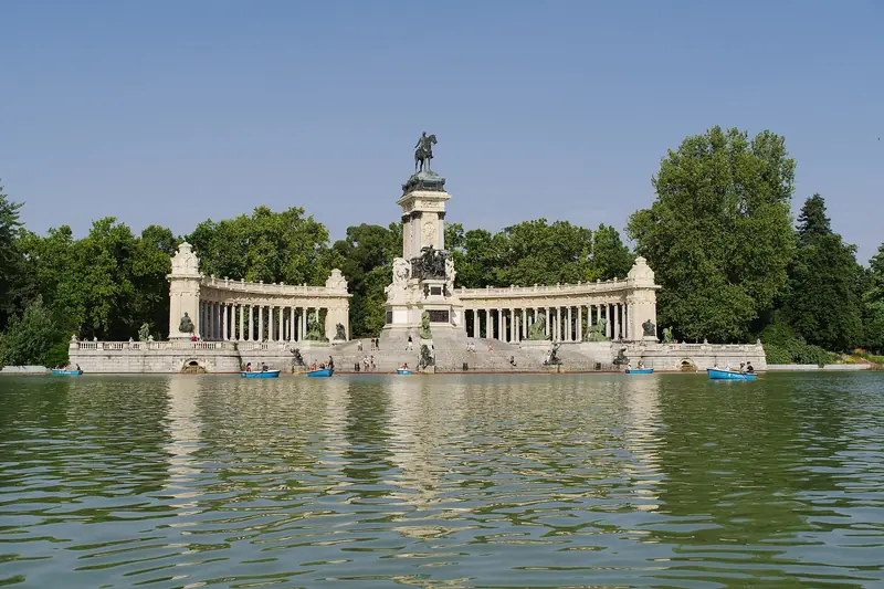 Lago do Retiro com barcos a remo azuis diante do monumento a Alfonso XII, com colunata semicircular