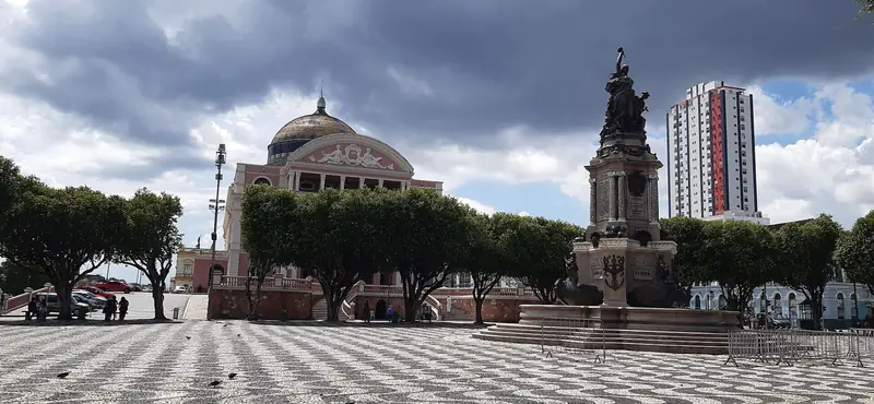 Largo de São Sebastião com o calçamento de pedras pretas e brancas, o monumento central e o Teatro Amazonas ao fundo