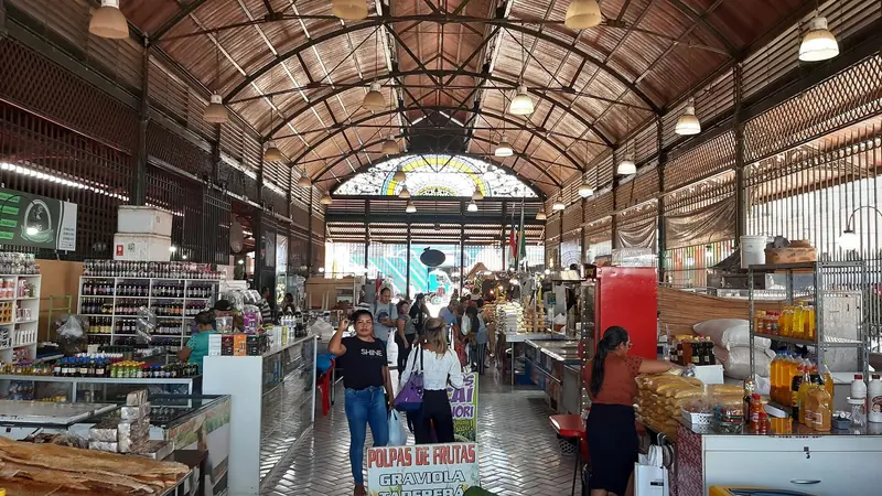 Corredor interno do Mercado Municipal Adolpho Lisboa, com bancas de polpa de frutas e estrutura de ferro