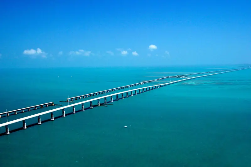 Vista aérea da Seven Mile Bridge atravessando o mar verde-azulado, com a ponte antiga paralela