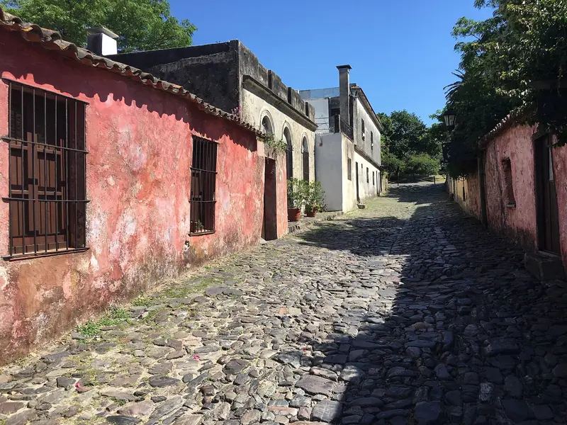 Calle de los Suspiros, em Colonia del Sacramento, com piso de pedras irregulares e casas antigas de paredes rosadas e brancas