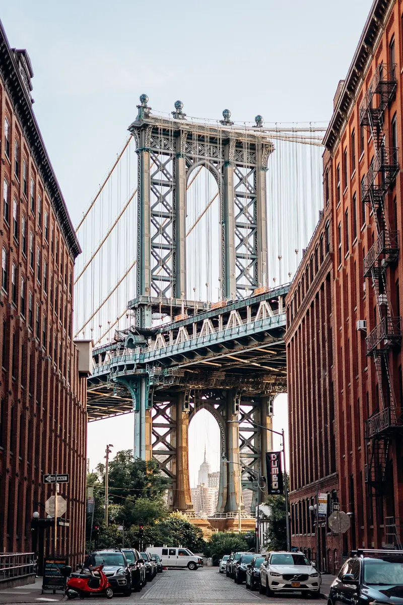 Ponte de Manhattan emoldurada pelos prédios de tijolo da Washington Street, em DUMBO, com o Empire State sob o arco