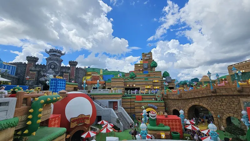 Super Nintendo World do Epic Universe, com o castelo do Bowser, canos verdes e blocos de interrogação