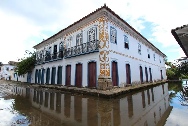 Rua do centro histórico alagada pela maré, com o casario refletido na água