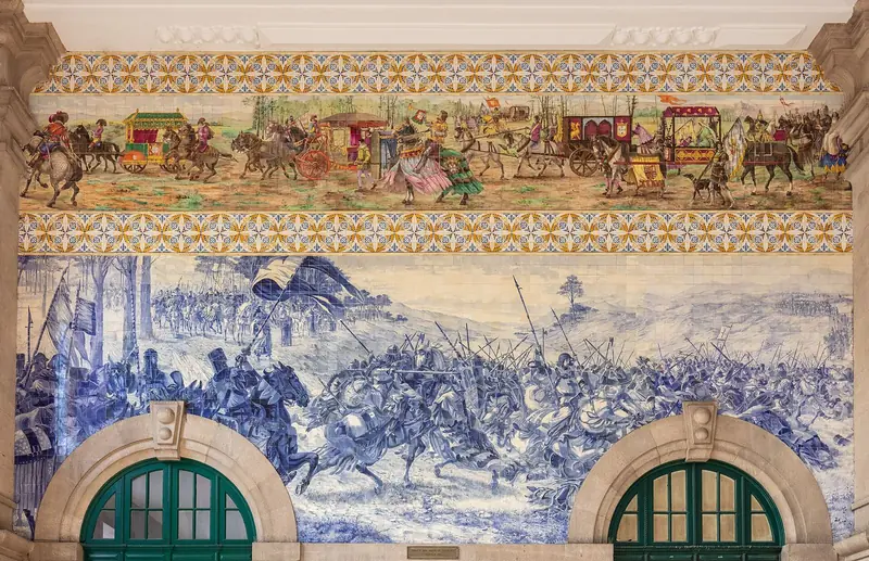 Painéis de azulejo azul e branco no saguão da estação de São Bento, no Porto, com cenas de batalha e um friso colorido acima