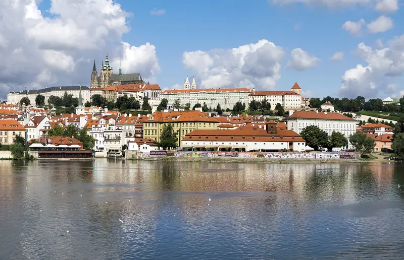 O Castelo de Praga e as torres da catedral de São Vito no alto da colina, sobre os telhados vermelhos de Malá Strana e o rio Moldava