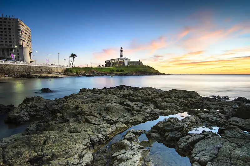 Farol da Barra ao entardecer, visto das pedras da orla