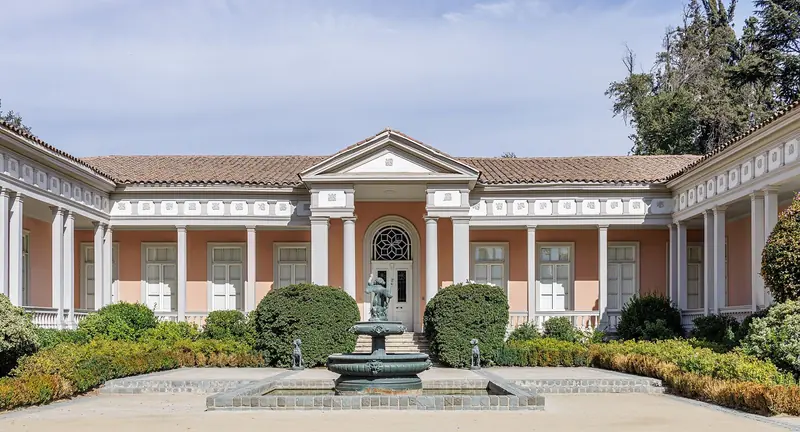 Casa patronal da Concha y Toro em Pirque, com fachada rosada, colunas brancas e fonte no jardim