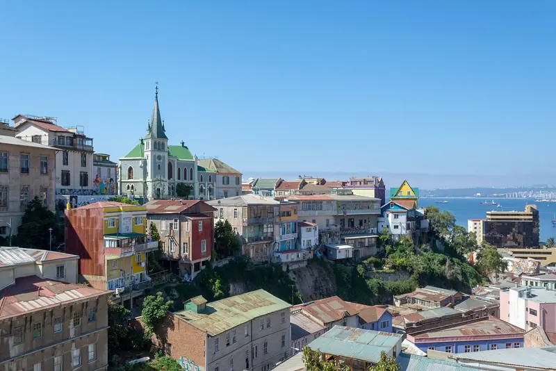 Casas coloridas do Cerro Concepción, em Valparaíso, com a igreja luterana de telhado verde e a baía ao fundo