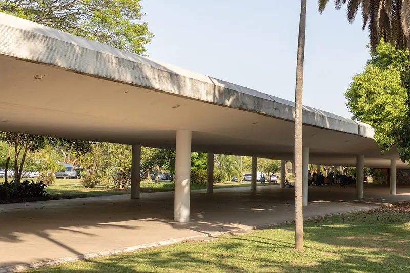 Marquise de concreto de Oscar Niemeyer sobre pilares, entre árvores do Parque Ibirapuera