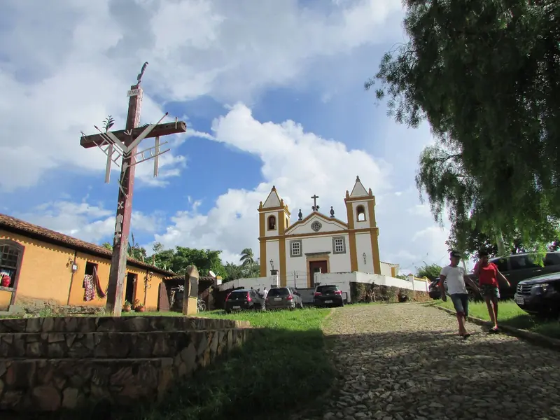 Igreja de Nossa Senhora da Penha, de duas torres, no alto de uma rua de pedra em Bichinho